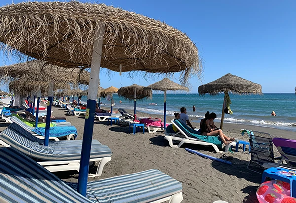 Beach in Torrox Costa, Spain, with soft sand and calm waters under a clear sky